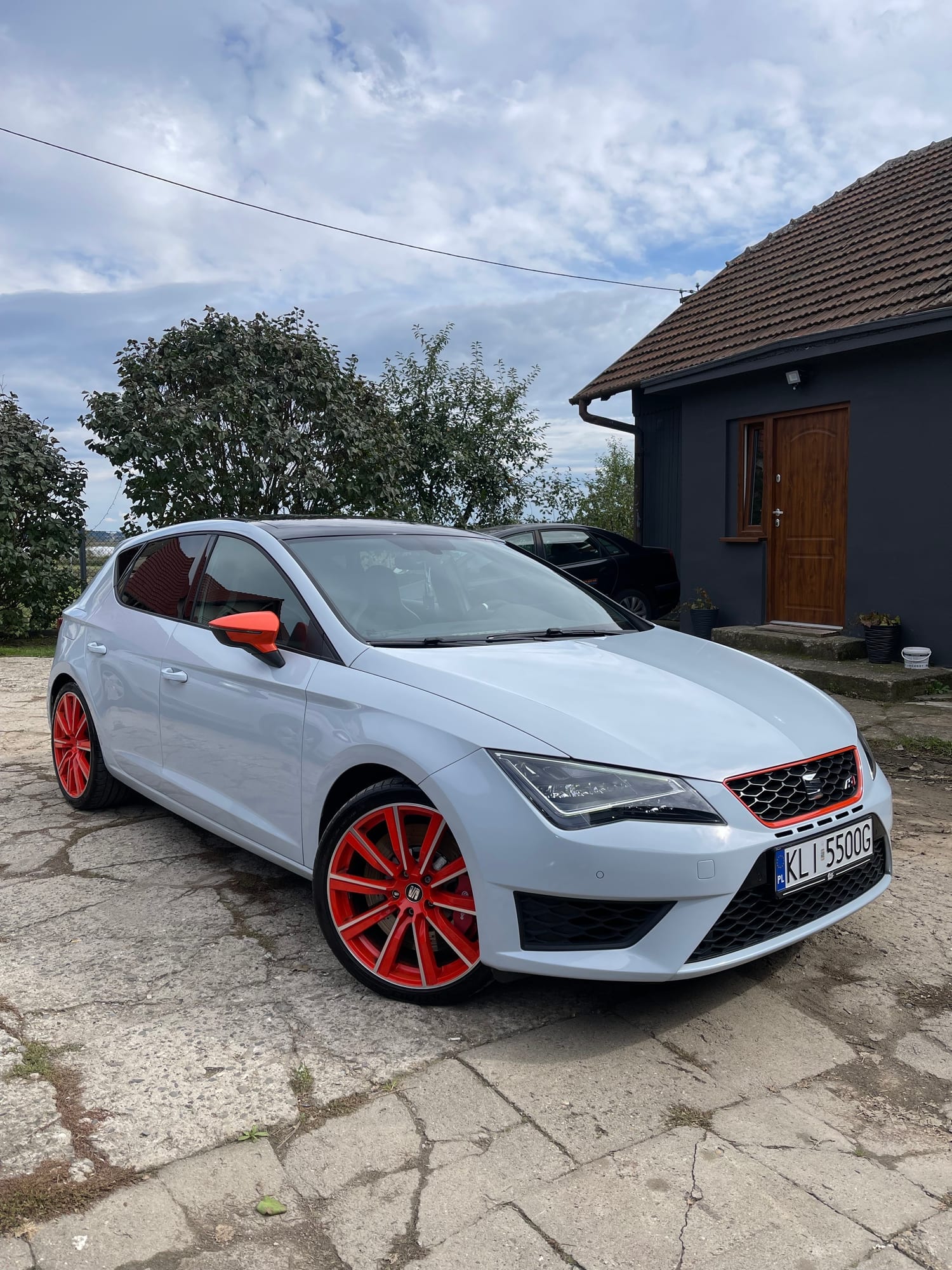 Biały Seat Leon Cupra z pomarańczowymi felgami po korekcie lakieru